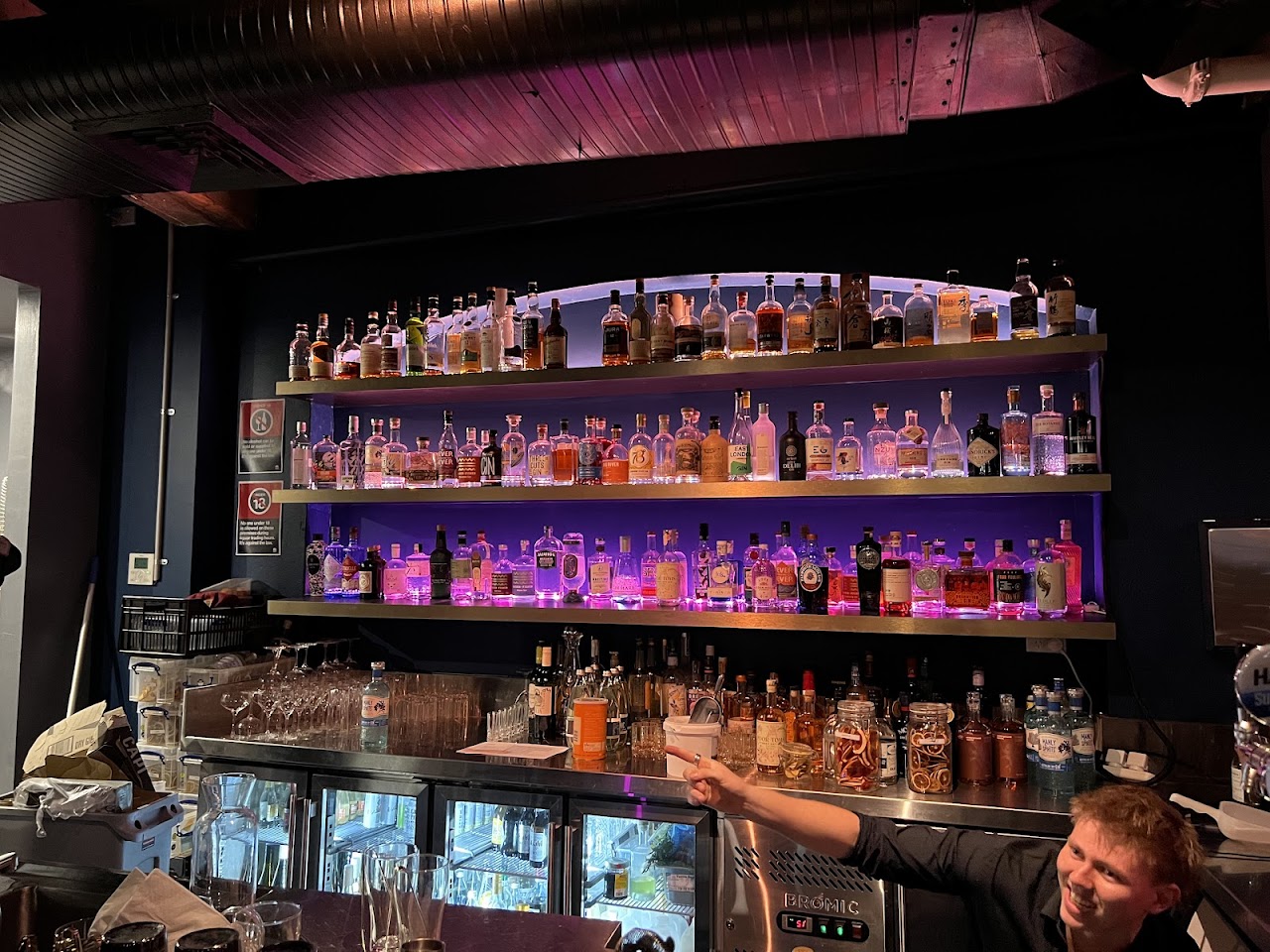 Backlit gin and whisky shelves at The Fox Hole bar